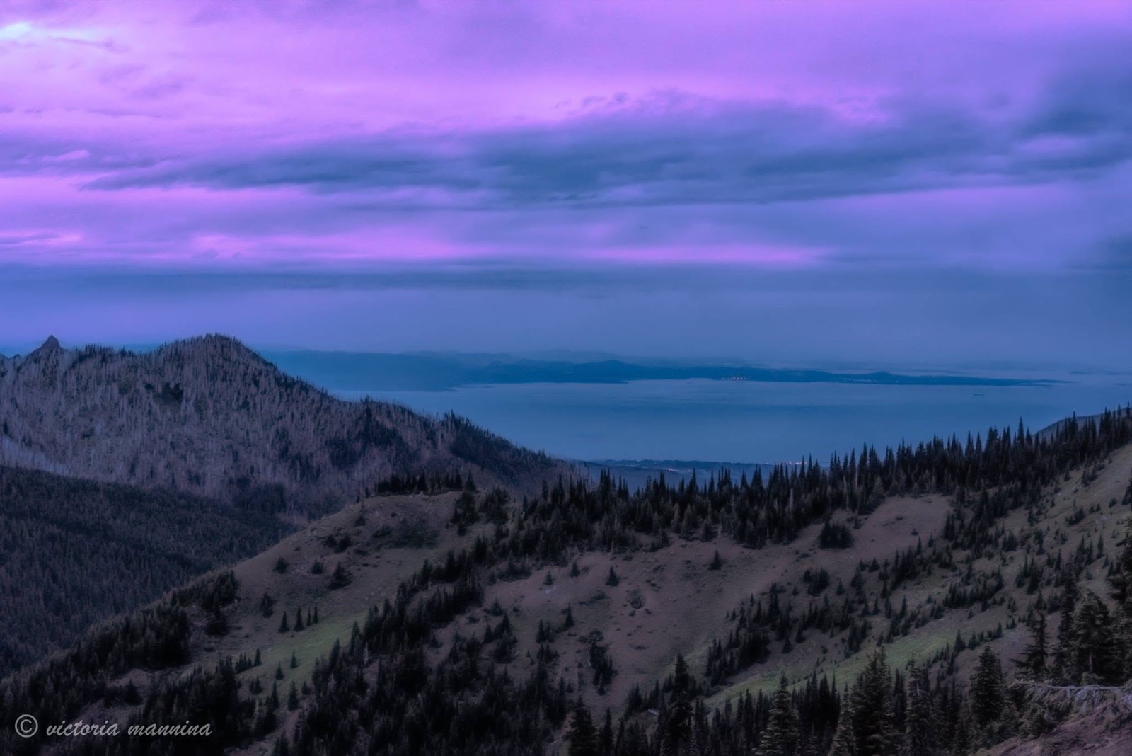 purple sunset sky over mountain ridge and lake