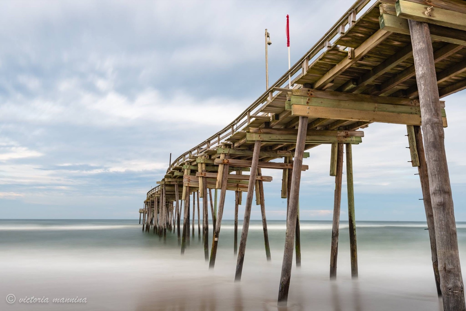 Wooden pier pilings over silky long-exposure sea