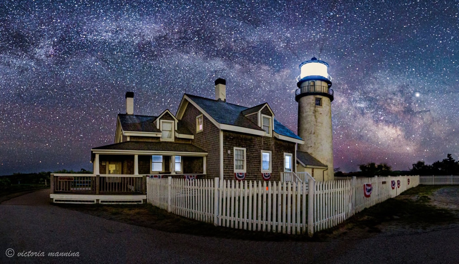 Lighthouse and keeper's cottage beneath a starry Milky Way sky